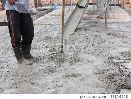 Construction worker spreading concrete mix  31814228