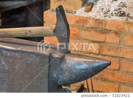 An anvil and a hammer in the old smithy 31823421