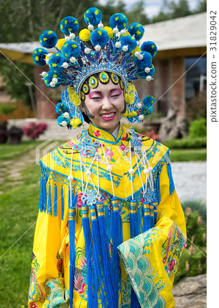 beautiful chinese girl in traditional chinese dress with long sleeves and hat standing outdoor beautiful chinese girl in traditional chinese dress with long sleeves and hat standing outdoor 31829042