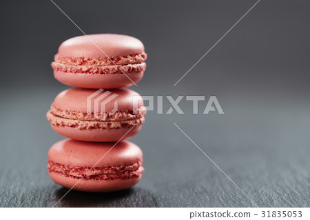 raspberry red macarons stacked on slate board 31835053