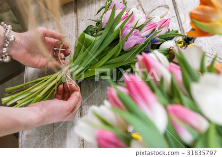 Woman packing tulip bouquet top view 31835797