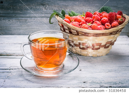 Cup of tea and basket with raspberry 31836458
