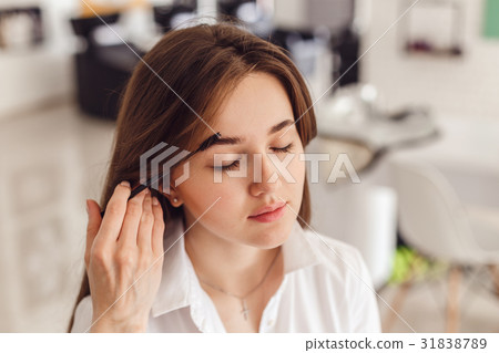 Woman correcting eyebrows form. 31838789