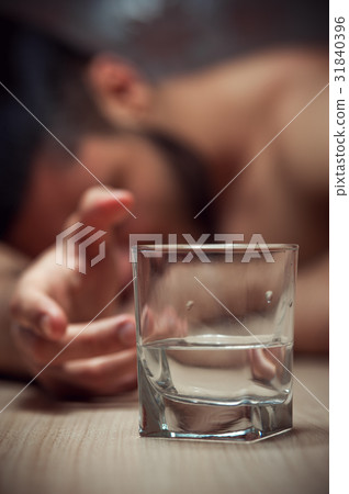 Drunken man sleeping with glass of alcohol 31840396