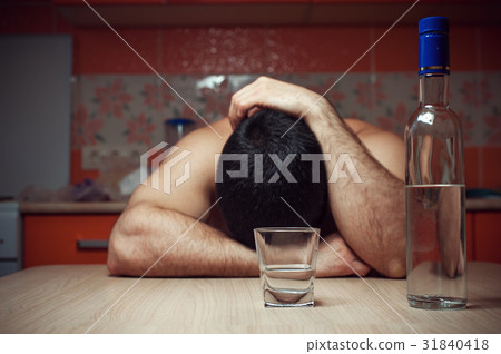 Alcohol addicted man sleeping at the table Alcohol addicted man sleeping at the table 31840418