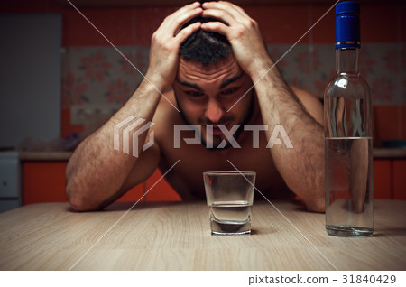 Sad depressed alcoholic man sitting at the table 31840429