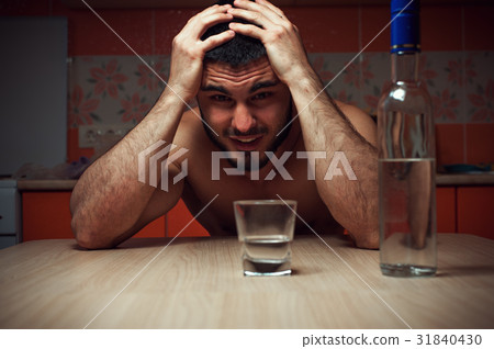 Angry depressed alcoholic man sitting at the table Angry depressed alcoholic man sitting at the table 31840430