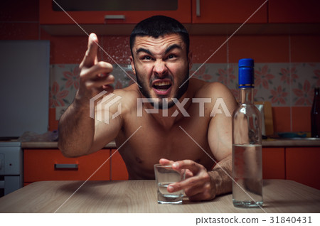 Angry depressed alcoholic man sitting at home 31840431
