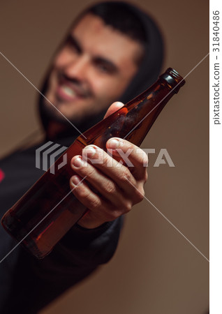 Young smiling man holding beer bottle in hands Young smiling man holding beer bottle in hands 31840486