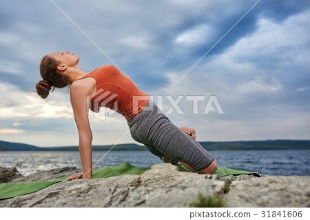 Beautiful young woman meditating in yoga pose on 31841606
