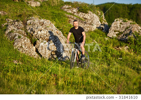 Attractive cyclist riding the bike on summer trail Attractive cyclist riding the bike on summer trail 31841610