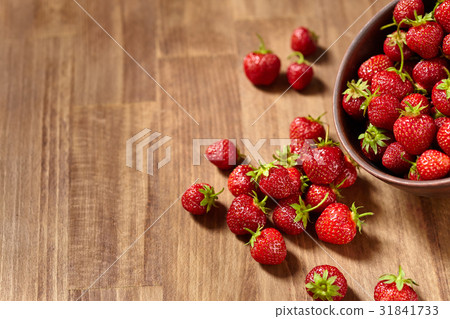 Fresh red strawberries in a brown clay bowl on Fresh red strawberries in a brown clay bowl on 31841733