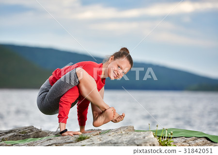 Young woman doing yoga pose arm balance on the 31842051