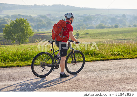 Attractive man in white helmet riding a bike on 31842929