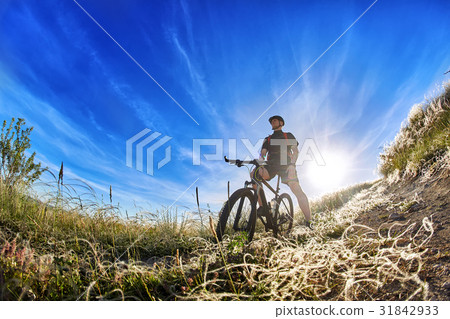 Low angle view of cyclist standing with mountain Low angle view of cyclist standing with mountain 31842933
