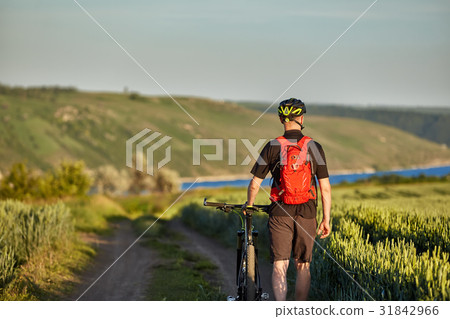 Rear view of the young cyclist riding bicycle on Rear view of the young cyclist riding bicycle on 31842966