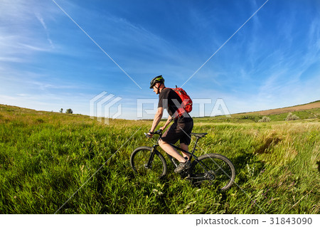 Young cyclist riding mountain bicyclist against Young cyclist riding mountain bicyclist against 31843090