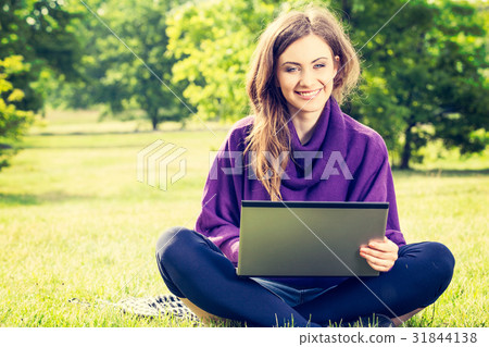 Young woman using laptop in the park Young woman using laptop in the park 31844138
