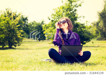 Young woman using laptop in the park 31844139