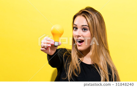 Young woman holding a light bulb Young woman holding a light bulb 31848240