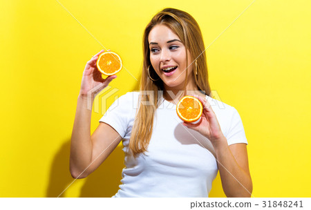 Happy young woman holding oranges halves Happy young woman holding oranges halves 31848241