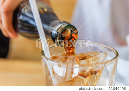 Close up of Pouring cola in a glass from a bottle 31849498
