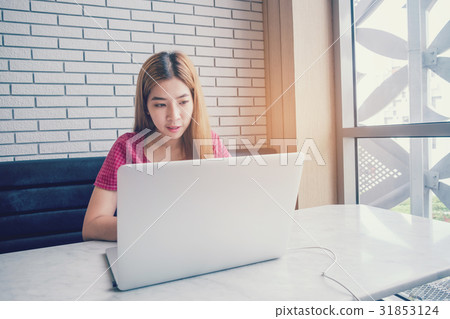 Asian girl working at a coffee shop with a laptop 31853124