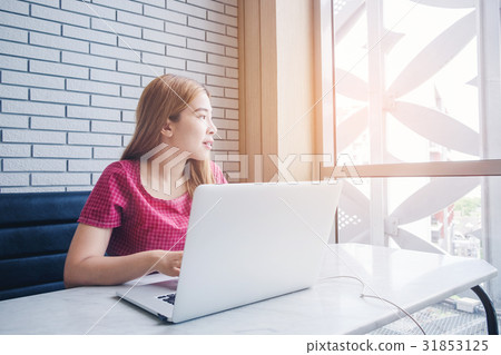 Asian girl working at a coffee shop with a laptop 31853125