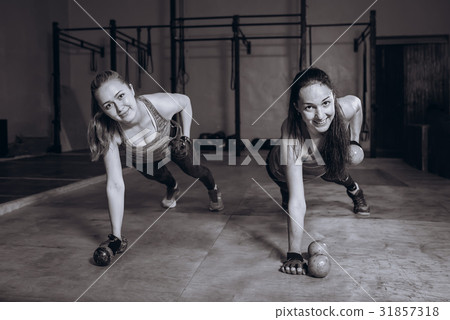 Two fit women in gym doing fitness exercises with 31857318