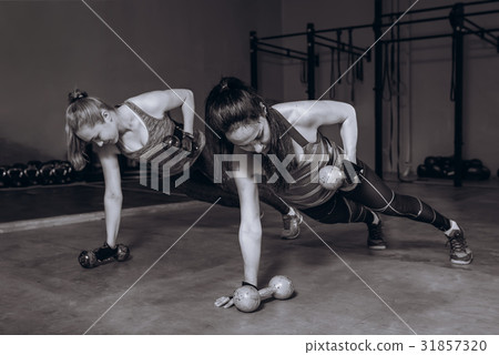 Two fit women in gym doing fitness exercises with Two fit women in gym doing fitness exercises with 31857320