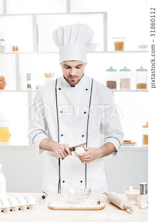 Chef in uniform breakseggs in bowl to prepare Chef in uniform breakseggs in bowl to prepare 31860112