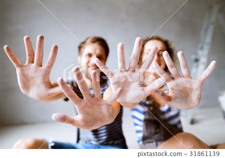 Young couple painting walls in their new house. Young couple painting walls in their new house. 31861139