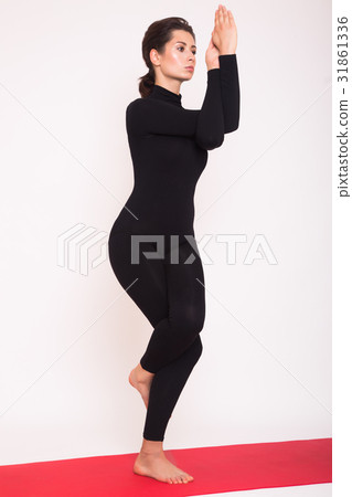 Beautiful athletic girl in black suit doing yoga Beautiful athletic girl in black suit doing yoga 31861336