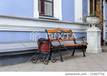 An empty wrought iron bench with wooden panels and 31867758