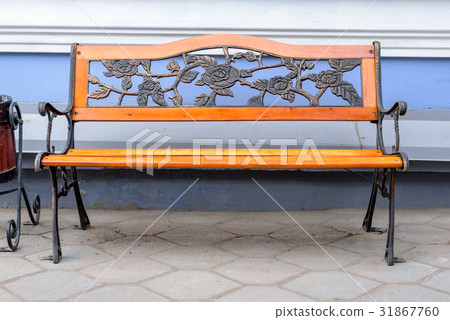 An empty wrought iron bench with wood accents 31867760