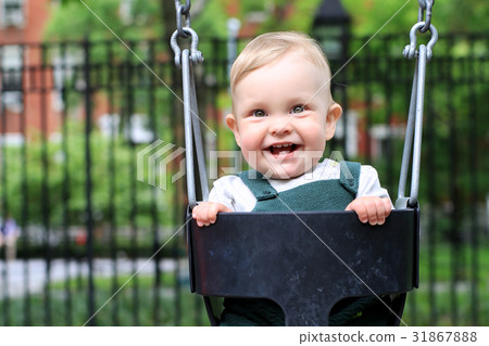 Little boy in overalls on the swing in the Park Little boy in overalls on the swing in the Park 31867888
