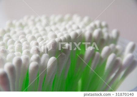 Green cotton swab bud over the grey background. Green cotton swab bud over the grey background. 31870140