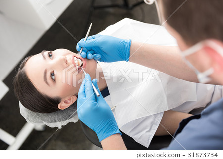 Odontologist examining teeth of happy woman Odontologist examining teeth of happy woman 31873734