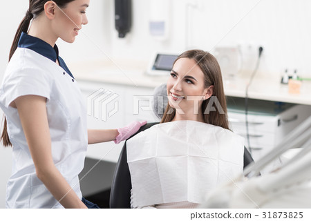 Outgoing girl speaking with odontologist Outgoing girl speaking with odontologist 31873825