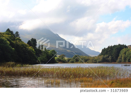 Mountain behind a lake under a moody sky Mountain behind a lake under a moody sky 31873989