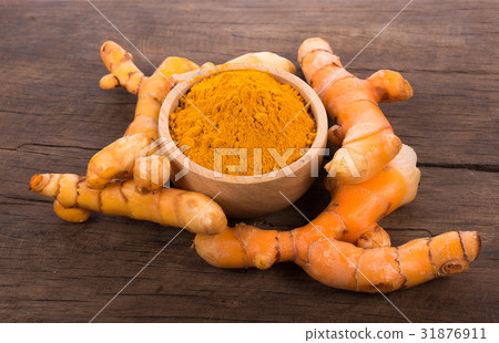 fresh turmeric roots on wooden background fresh turmeric roots on wooden background 31876911