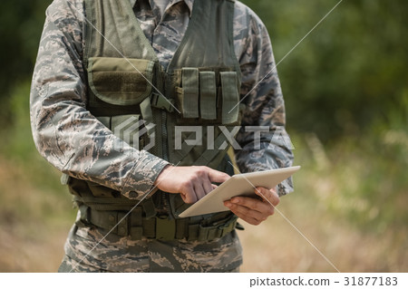 Mid section of military soldier using digital tablet 31877183