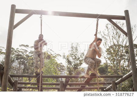 Military soldiers climbing rope during obstacle course training 31877627