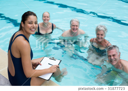 Happy female trainer and senior swimmers Happy female trainer and senior swimmers 31877723