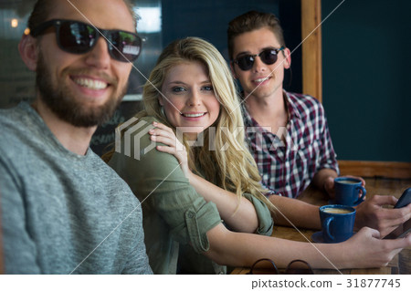 Happy male and female friends at table in cafe Happy male and female friends at table in cafe 31877745