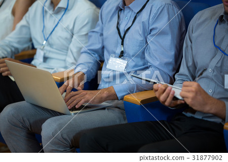 Business executives participating in a business meeting using electronic devices 31877902