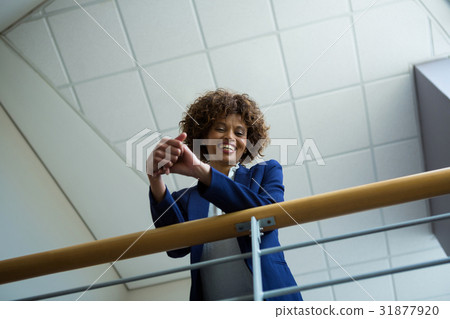 Businesswoman leaning over the railing of staircase 31877920