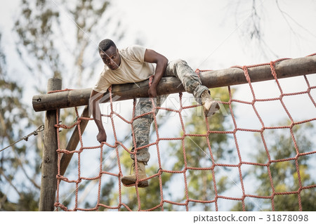 Military soldier climbing net during obstacle course Military soldier climbing net during obstacle course 31878098