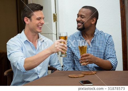 Cheerful friends toasting beer glasses in restaurant 31878573
