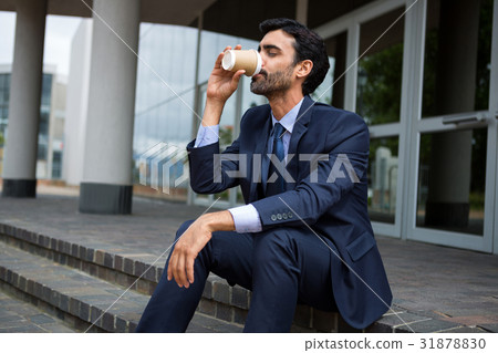 Businessman drinking coffee from disposable cup 31878830